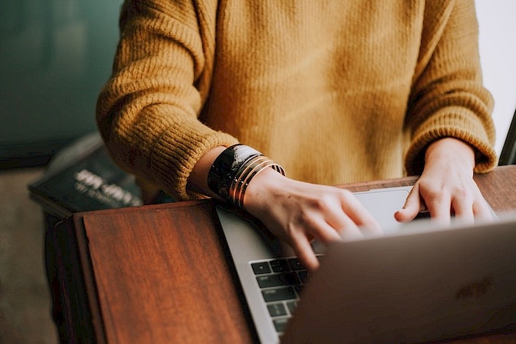 Woman typing on a laptop.